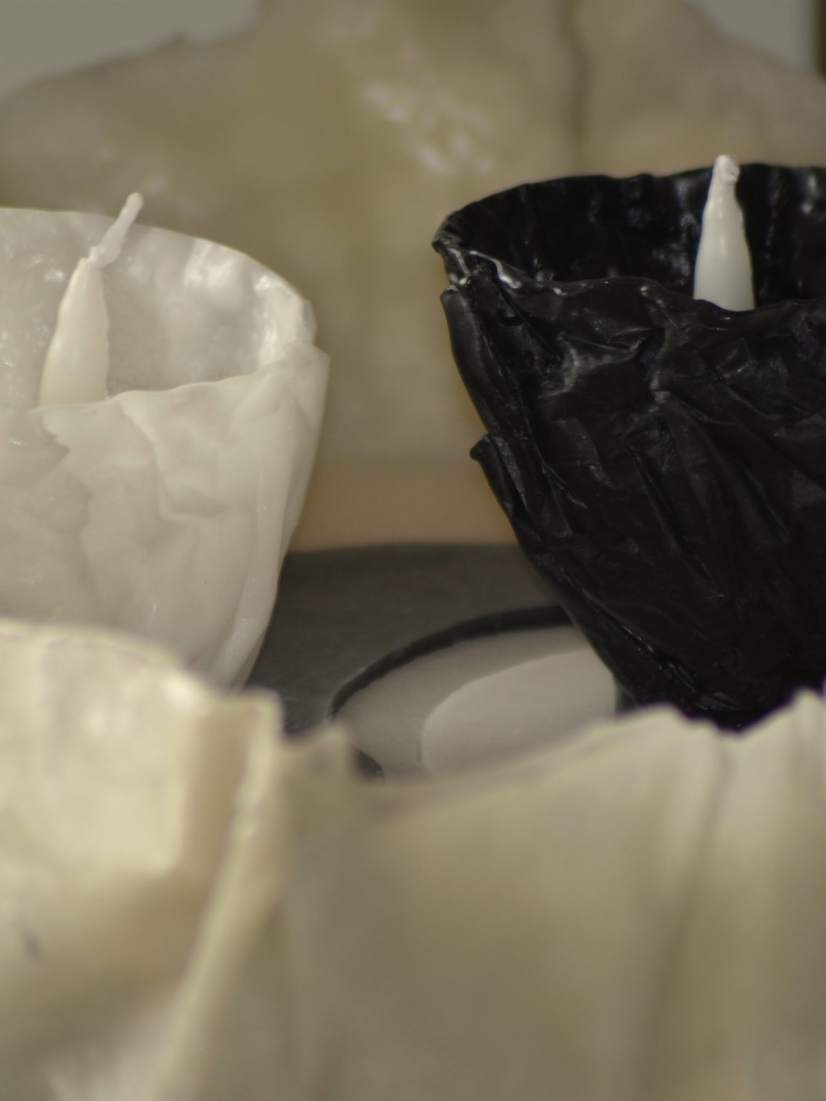 Piezas de cera blanca y negra moldeadas a mano en el taller de Creative Velas